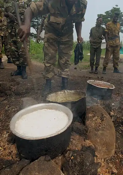 Burundian soldiers cooking in a sufuria over an open fire