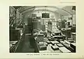 Sepia photograph of a room crowded with display cabinets and work benches