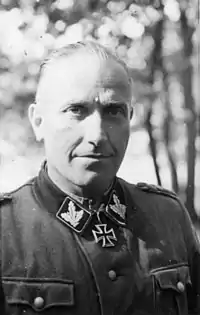 Black-and-white portrait of a man wearing a military uniform with an Iron Cross displayed at his neck.