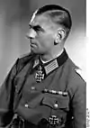 Black-and-white portrait of a man in semi profile wearing a military uniform with an Iron Cross displayed at his neck.