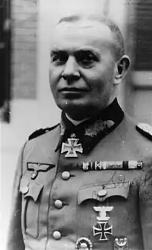 A man wearing a military uniform with an Iron Cross displayed at the front of his uniform collar.