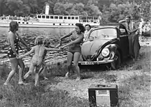 Original caption: "Family playing by a river with a KdF-Wagen and radio receiver", c. 1939