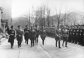 Werner von Blomberg inspects a parade in honor of the 40th anniversary of his joining the army. Soldiers with guns stand to attention.