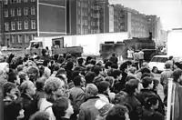 A large crowd looking at road construction work in preparation for the border crossing between West Berlin (front of picture) and East Berlin (behind the wall) on 11 November 1989.