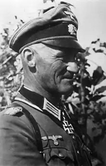 A man wearing a military uniform with an Iron Cross displayed at the front of his uniform collar.