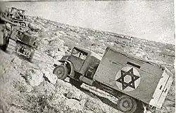 A bulldozer tows a truck on the "Burma road", June 1948