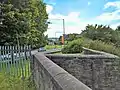 A view along the surviving section of north-west wall. Today part of the A671 and the roundabout on the southern side of the motorway junction run across the site.