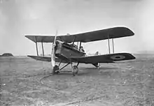 Three-quarter view of military biplane on landing ground