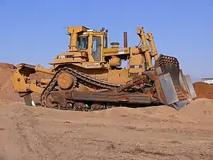 The Caterpillar D10N bulldozer evolved from tracked-type tractors and is characterized by a steel blade attached to the front that is used to push other equipment and construction materials, such as, earth.