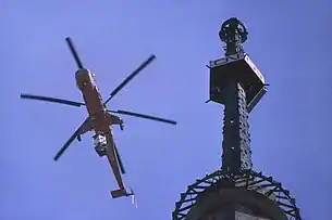 Helicopter lifting part of antenna, March 1975