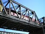 A steel truss bridge with a locomotive on it.