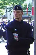 A CRS police officer in normal gear, standing by a Bastille Day parade