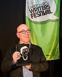 Neil Cross holds up the Ngaio Marsh Award