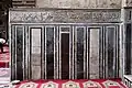 Marble mosaic panels and marble inscription band (in Kufic Arabic script) along the walls of the main courtyard