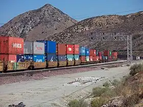 A BNSF double-stack train passing through Cajon Pass in California, with a mix of 20-foot  and 40-foot containers