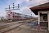 A train passing a small flag stop shelter