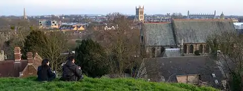 Cambridge skyline viewed from the mound. The church in the foreground at right is St Giles' Church, the spire on the left is part of All Saints' Church, the tower in the centre is part of St John's College chapel, and the long roofline on the skyline at right is King's College Chapel.