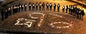 Semicircle of demonstrators holding candlelight vigil