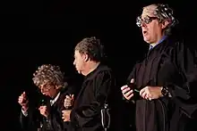 Three men onstage in judicial robes