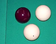 Image 23A set of standard carom billiard balls, comprising a red object ball, one plain white cue ball, and one dotted white cue ball (replaced in modern three-cushion billiards by a yellow ball) for the opponent (from Carom billiards)