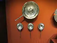 Shallow bowl above three silver spoons