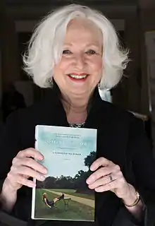 Gildiner holding a copy of the third installment in her memoir trilogy, Coming Ashore