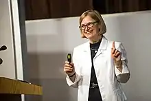 Hickson speaking, next to a podium, at the University of the Fraser Valley