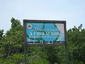 Welcome sign at boat landing of Cayo Aurora, mangrove forest in the background