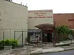 Facade of a two story school surrounded by a chain-link wire