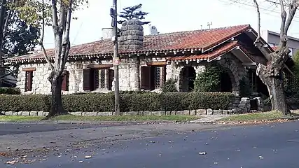 A full stone-covered chalet with a rectangular, long layout and "embedded" portico-style porch