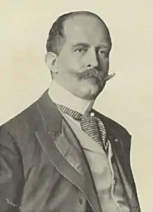 Mustachioed man in a suit