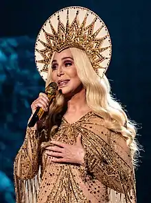 A photograph of Cher performing in London during her Here We Go Again Tour in October 2019