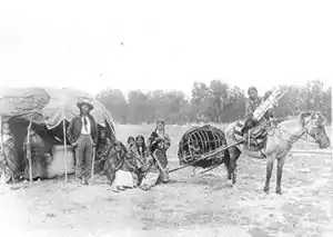 Image 12Stump Horn and family (Northern Cheyenne); showing home and horse-drawn travois. (from History of Montana)