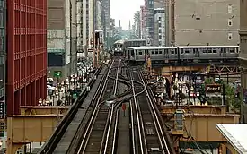 An Orange Line train (behind the turning train) at the northern end of the South Side Elevated branch