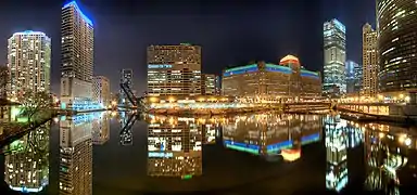 Night-time scene showing brightly-lit skyscrapers reflecting in the Chicago River