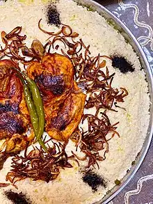 A picture of Chicken Saleeg decorated by ghee and fried onion.