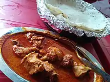 A chicken curry from Maharashtra, India with rice flour chapatis. The dish is popular worldwide.