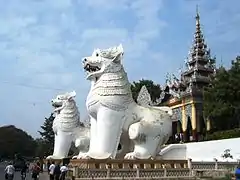 A pair of whitewashed lions guard the entrance to Mandalay Hill