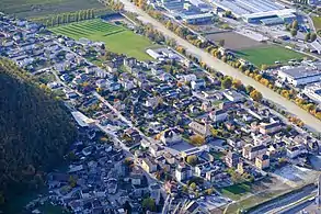 Village seen from above next to a river. Streets and houses are easily distinguishable.