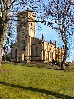 19th century stone church with side aisles and bell gable