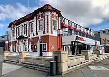 image of building with red, black and white brick work, windows and details