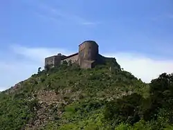 photograph of a one-storey stone fortress and its tower on a hilltop