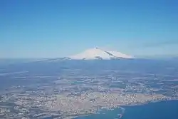 An aerial view of the Metropolitan City around Catania. Mount Etna is the peak at a distance.