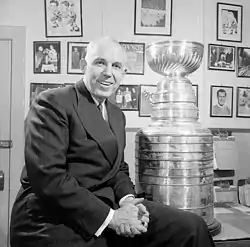 Campbell sitting on his desk with the Stanley Cup