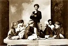 A private class at home in Vietnam about 1895. Picture depicts children and teacher wearing turbans.