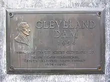 Commemorative plaque affixed to the Cleveland Dam along the walkway.