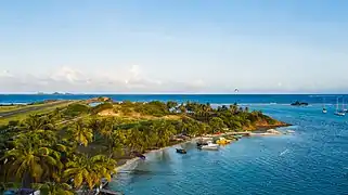 Aerial view of a beach on Union Island near Clifton with the Union Island Airport in the background.