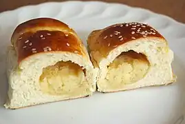 A cross-section view of a cocktail bun, revealing the coconut filling