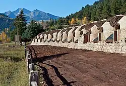 A portion of the same structures shown in the first image, but with fresh stonework giving them a consistent shape and fresh soil in front.