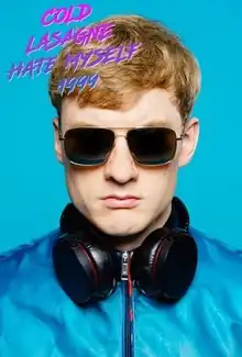 Acaster wearing a blue jacket, headphones and sunglasses